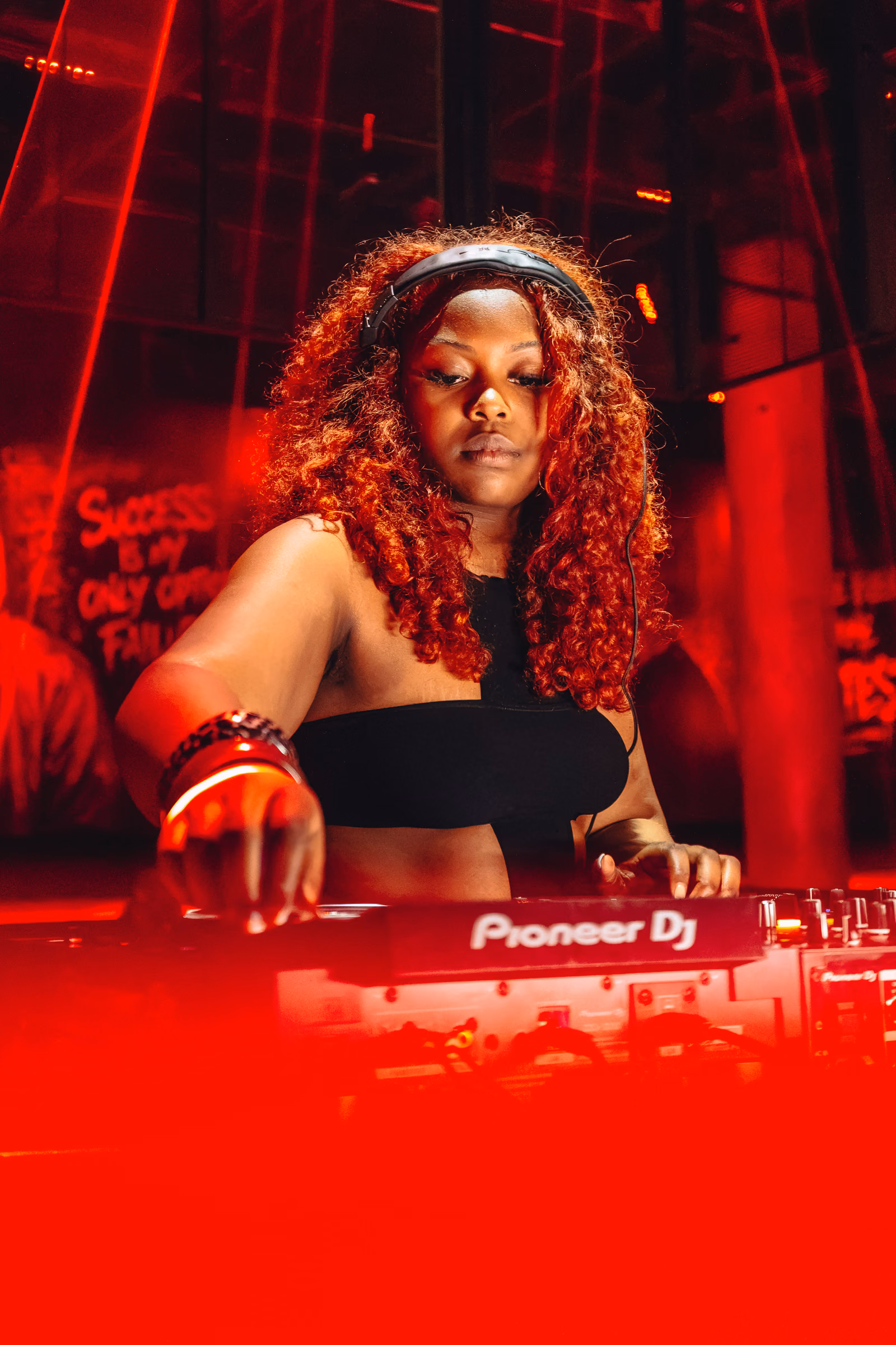 DJ mixing under red lighting at a nightclub