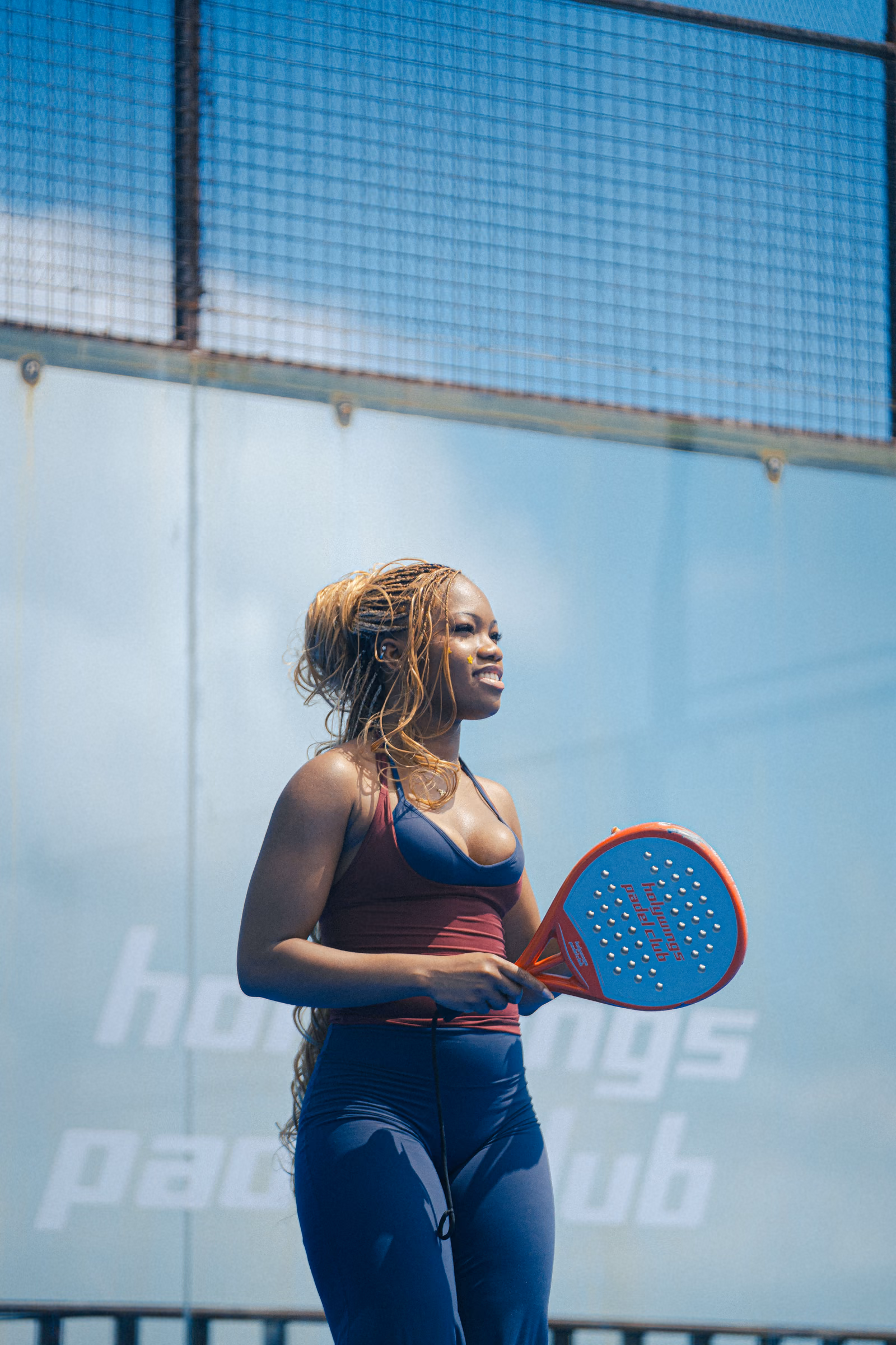 Padel player holding a red racket on an outdoor court