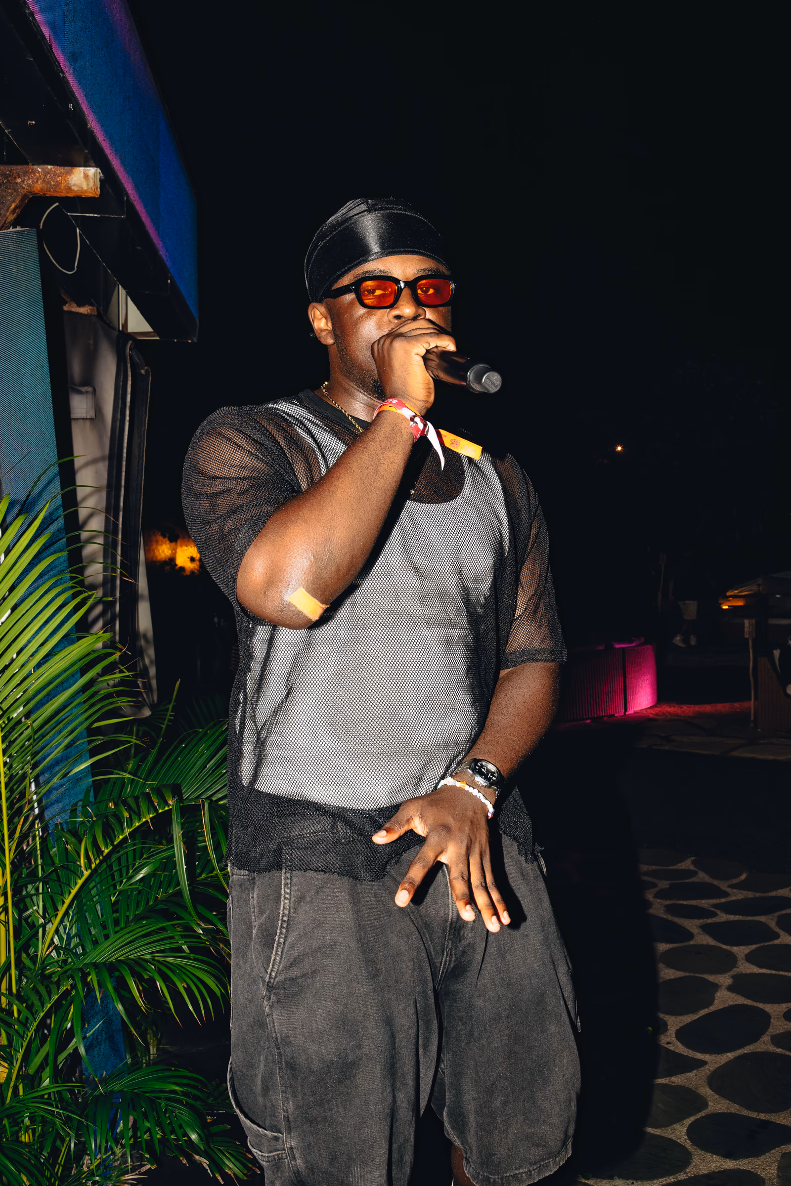 Performer singing into a microphone at an outdoor nighttime event