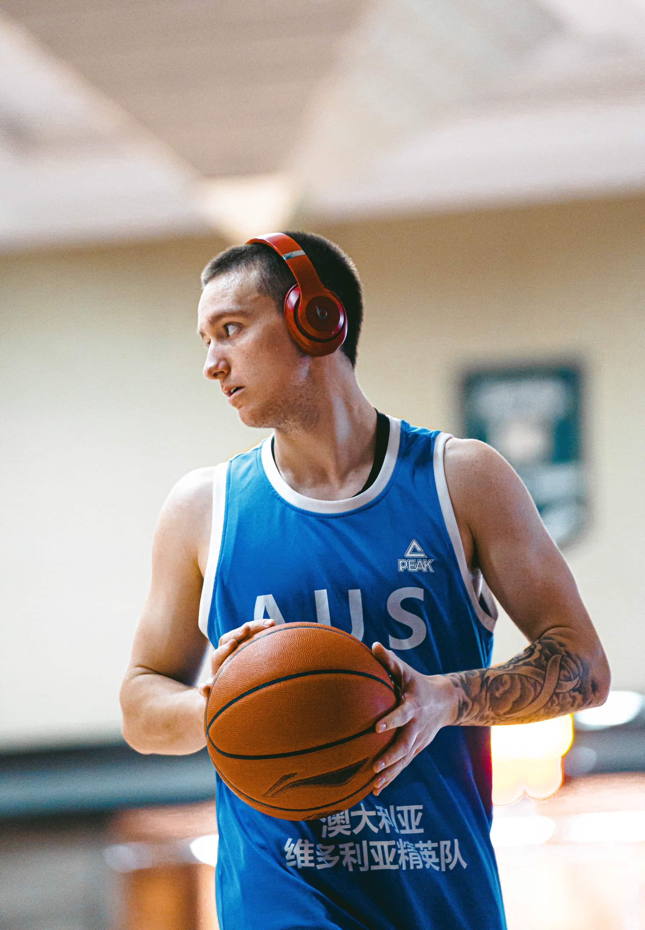 Basketball player wearing red headphones and holding a ball