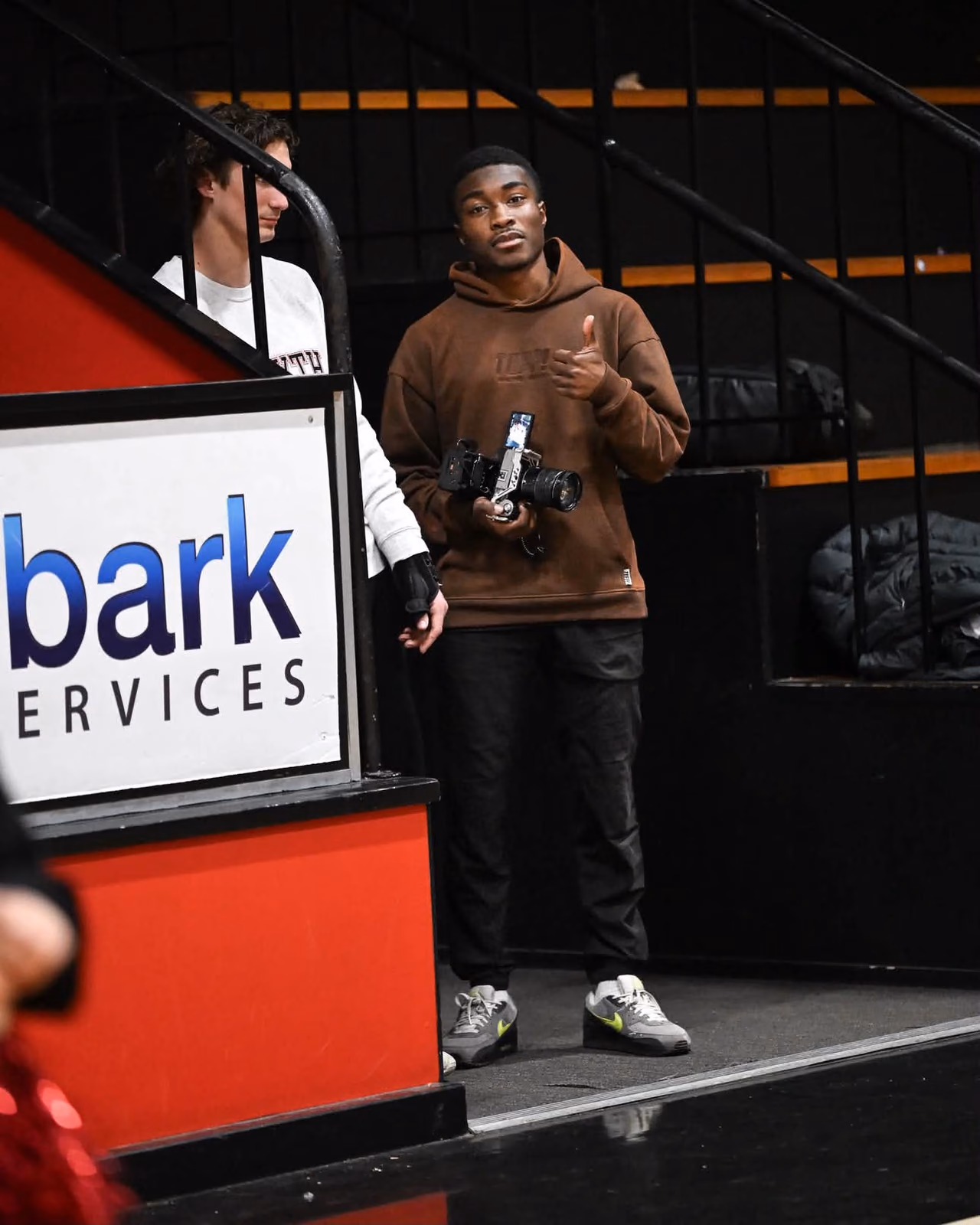 Olu checking his camera beside the basketball court