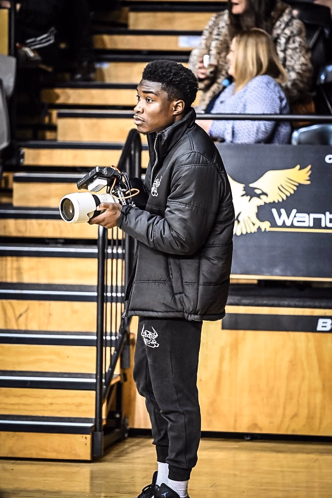 Olu holding his camera courtside
