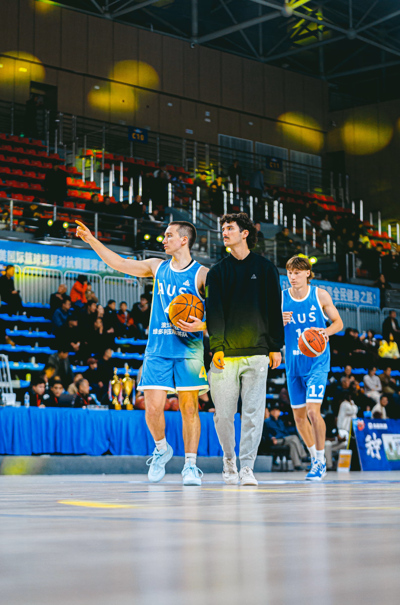 Australian basketball players talking courtside in an arena