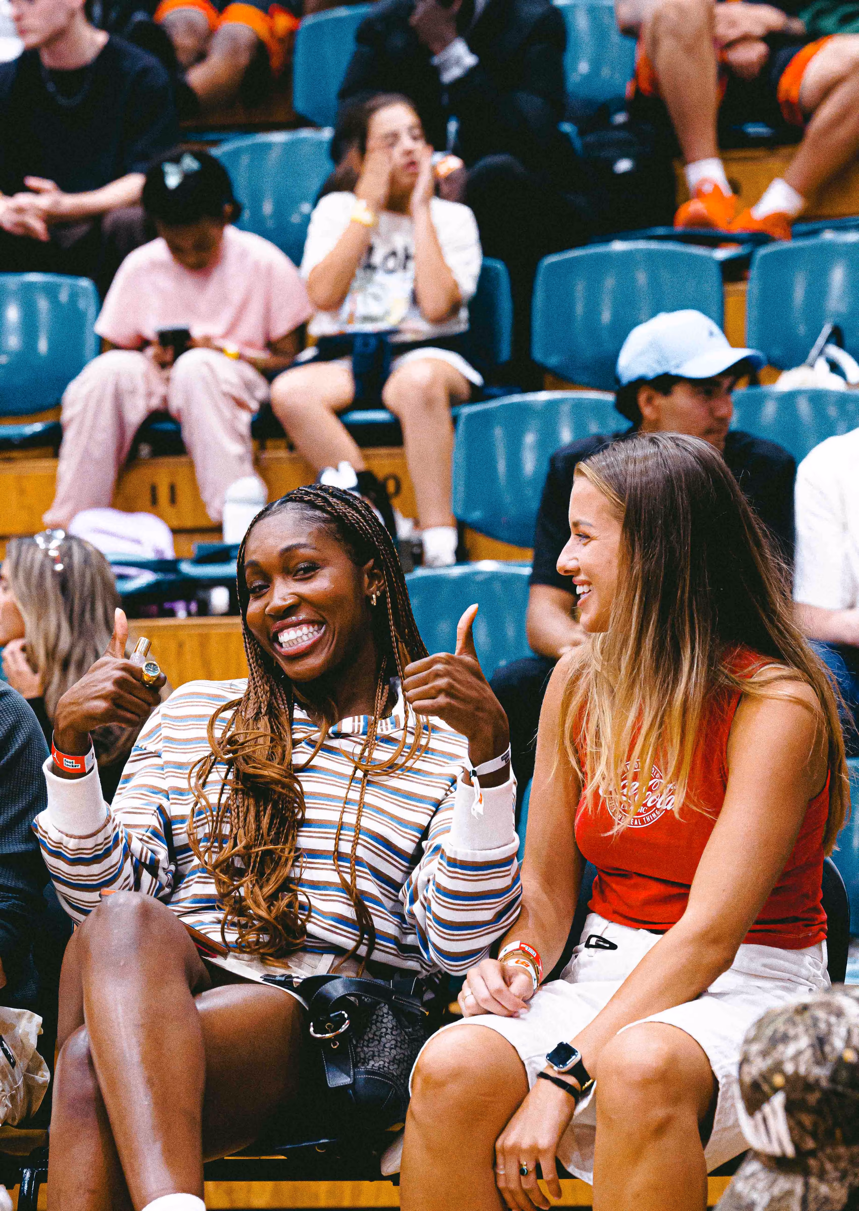 Two spectators smiling together in a basketball arena