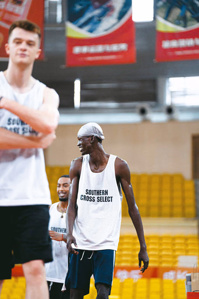 Basketball player smiling with teammates during a gym session