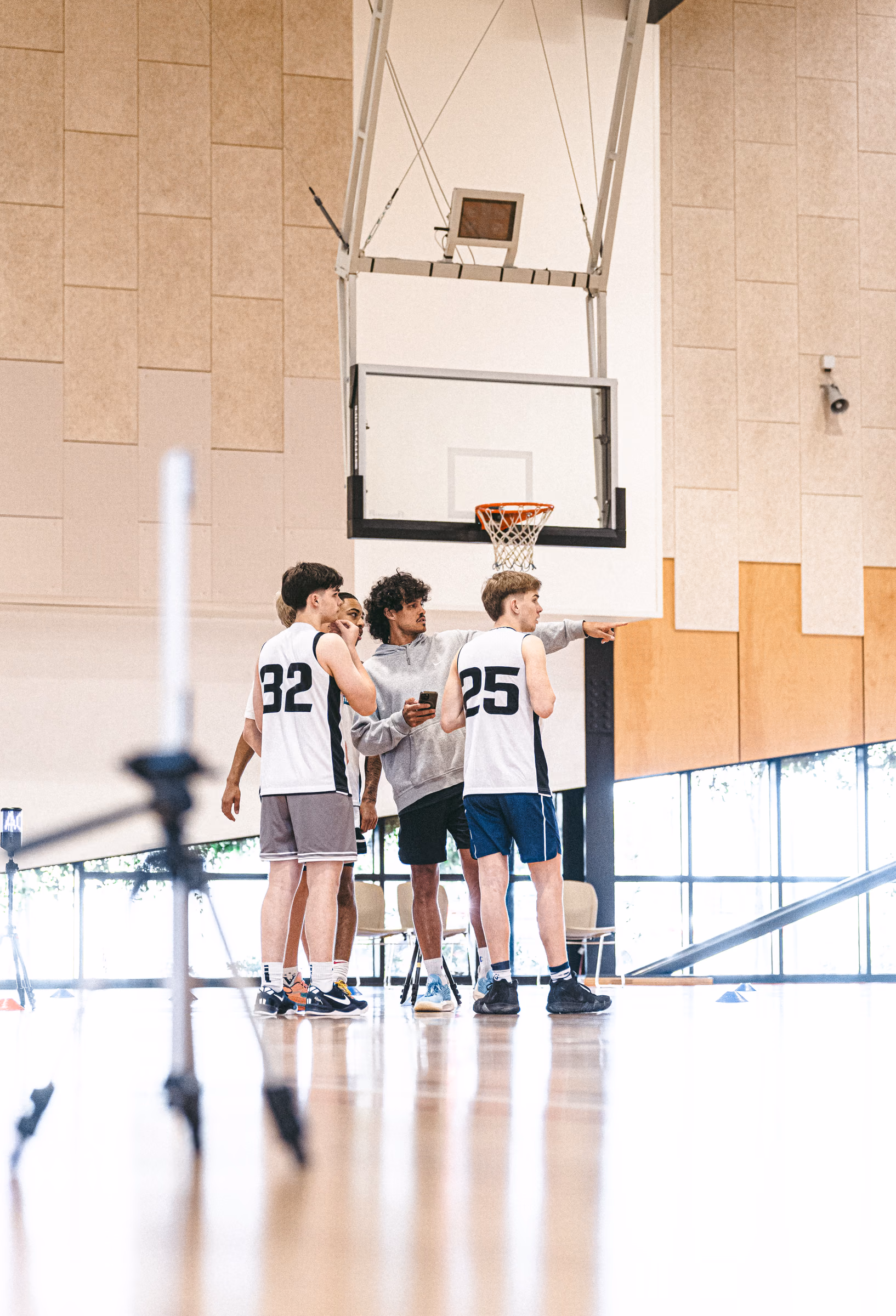 Basketball prospects huddled beneath a hoop during a combine